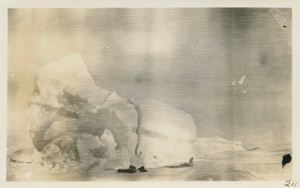 Image of Iceberg forced against the land; sledge in the foreground